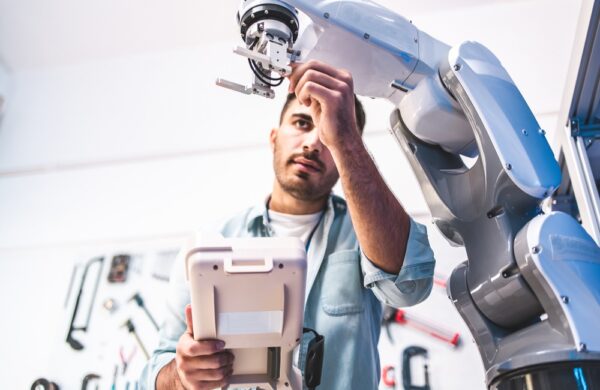 Male Engineers Maintenance Robot Arm at Lab