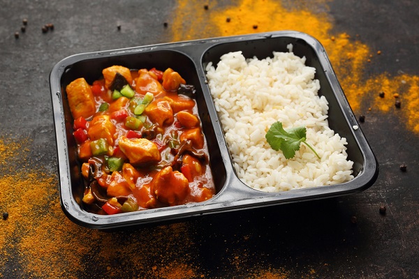 Chinese style chicken with white rice. Ready dish in a black container