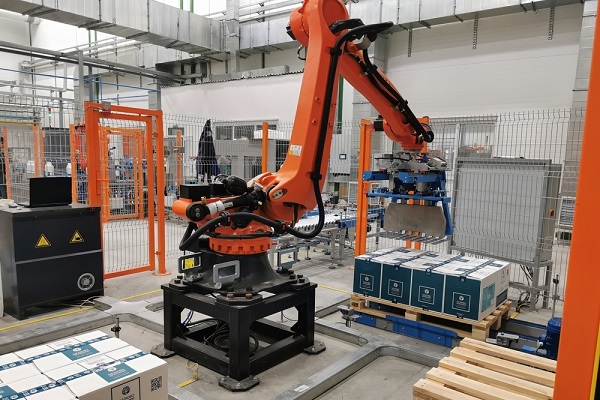 Robot palletizer orange KUKA robot kr180 stacks boxes on a pallet