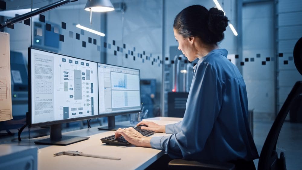 Beautiful and confident female industrial engineer working on computer