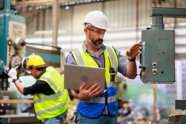 Engineering working with team and digital tablet computer in safety hardhat