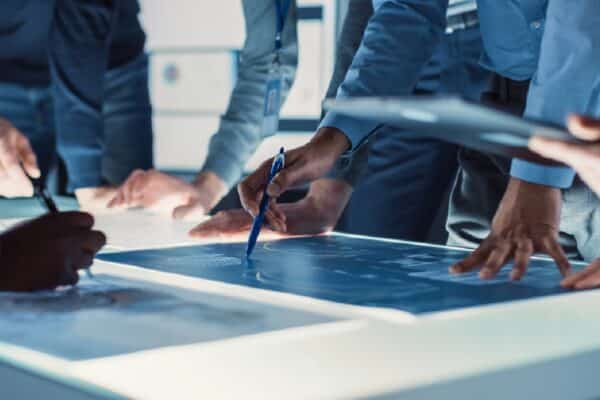 Engineer, Scientists and Developers Gathered Around Illuminated Conference Table